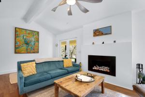 a living room with a blue couch and a fireplace at Red Bird Cottage in Wimberley