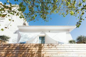 uma casa branca com escadas que levam até ela em Shurhuq Ospitalità Siciliana em Avola