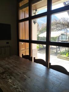 a table and chairs in a room with a window at La Casa del Lago in Porlezza