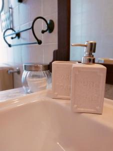a bathroom sink with a soap dispenser on it at La Casa del Lago in Porlezza +52 photos