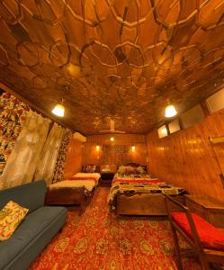 シュリーナガルにあるLuxury freedom group of houseboatsのベッド2台とソファが備わる客室です。 +3枚の写真