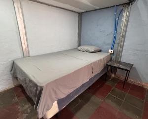 a small bed in a room with a side table at La Casita de Nataly in Santa Ana +3 photos