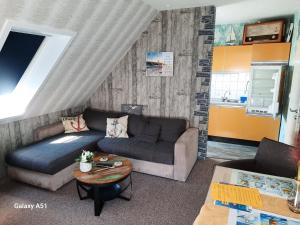 a living room with a couch and a table at FeWo Fuhrmann in Bensersiel