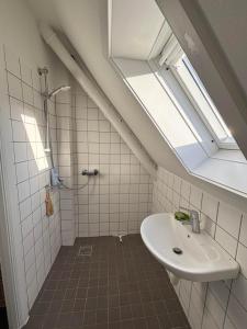 a bathroom with a sink and a shower with a skylight at Kleiters Bed & Kitchen in Copenhagen +17 photos