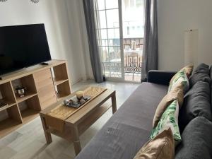 a living room with a couch and a tv at PUERTO I Playa in Fuengirola