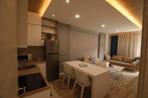a kitchen and living room with a table and a couch at Elio Apartament in Pogradec