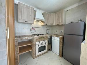 una cucina con elettrodomestici bianchi e armadietti in legno di Apartment Aurora - Affitti Brevi Italia a Manfredonia