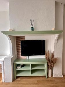 a tv on a shelf in a living room at Halte Provençale à Manosque - Centre Historique in Manosque