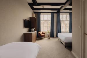 a hotel room with two beds and a window at Adam's Canal House in Amsterdam