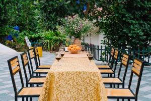 a long table with chairs and oranges on it at Private Balcony Hotel in Cat Ba