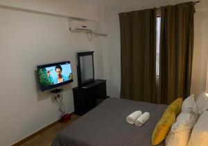a bedroom with a bed and a flat screen tv at Les Lavandins-Yaoundé in Yaoundé