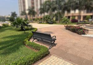 a park bench sitting on a sidewalk in a park at Les Lavandins-Yaoundé in Yaoundé