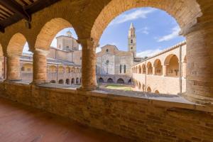 an arcade in a building with a church in the background at Al Belvedere Apartment II in Atri