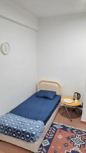a bedroom with a bed with blue sheets and a table at Muscat Women's dormitory in Muscat