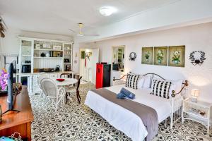 Un dormitorio con una cama blanca y una cocina. en Villa Bel Fiori Apartment - 4 Sleeper, en Ballito