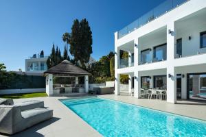 a house with a pool and a gazebo at Villa Angelique, 5 BDR with Heated Private Pool in Puerto Banus in Marbella