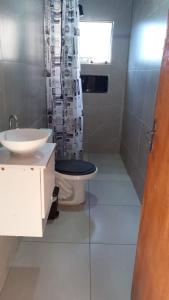 a bathroom with a toilet and a shower curtain at Recanto Eucaliptos in Araçoiaba da Serra