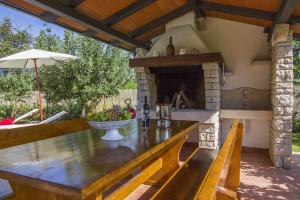 an outdoor kitchen with a stone fireplace on a patio at Villa Gloria, a beautifully and modernly furnished villa in Nedeščina