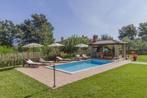 a swimming pool with chairs and a gazebo at Villa Gloria, a beautifully and modernly furnished villa in Nedeščina