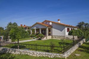 a house with a fence in front of a yard at Villa Gloria, a beautifully and modernly furnished villa in Nedeščina