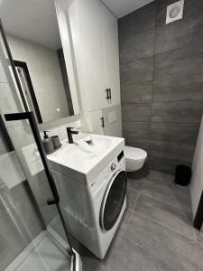 a bathroom with a washing machine and a sink at Apartment - Kauno 23 in Klaipėda