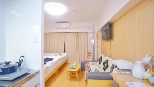 a small living room with a couch and a bed at TOKYO ICHIBAN SHINJUKU in Tokyo
