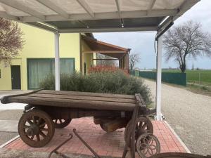 a wooden cart with a planter on the side of a building at La Barca di Grano in SantʼAgata Bolognese +10 photos