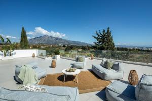 a patio with couches and a table with a view at Villa Angelique, 5 BDR with Heated Private Pool in Puerto Banus in Marbella