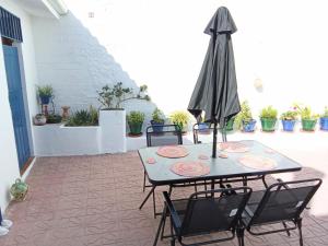 a table with chairs and an umbrella on a patio at Casa Palomar in Alcaudete