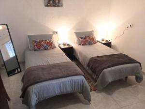 two beds in a room with two lamps on them at Casa Palomar in Alcaudete