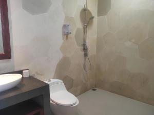 un baño con inodoro y ducha en Cozy apartments in a residential area of Nusa Dua, en Nusa Dua 2 fotos más