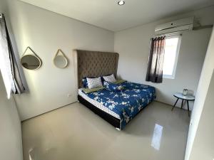 Un dormitorio con una cama con un edredón azul. en Cozy apartments in a residential area of Nusa Dua, en Nusa Dua