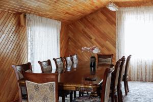 a dining room with a wooden table and chairs at Lakeside Villa Issyk Kul in Cholpon-Ata