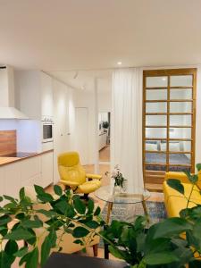 un salon avec une chaise jaune et une table dans l'établissement An Attractive Paris Flat near Jardin du Luxembourg , Saint-Germain, à Paris