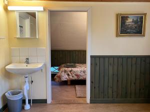 a bathroom with a sink and a mirror and a bed at Skagagården-peaceful stay near Tiveden National Park in Undenäs