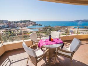 a table and chairs on a balcony with a view of the ocean at Apartments Raymond in Sveti Stefan