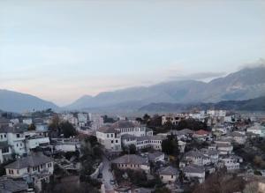 a view of a city with mountains in the background at Perkli Bezhani Rooms in Gjirokastër