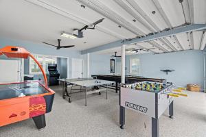 a room with two tables and a pool table at Forever Coastal With Game Room And Private Beach in Destin