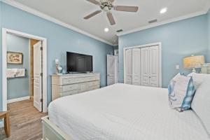a bedroom with a bed and a flat screen tv at Forever Coastal With Game Room And Private Beach in Destin