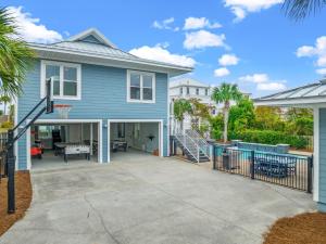 a blue house with a basketball hoop at Forever Coastal With Game Room And Private Beach in Destin