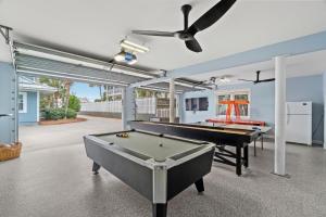 a room with a pool table and a ceiling fan at Forever Coastal With Game Room And Private Beach in Destin