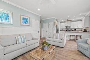 a living room with a couch and a table at Forever Coastal With Game Room And Private Beach in Destin