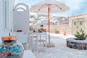 a patio with an umbrella and a table and chairs at Ostria Apartments in Akrotiri