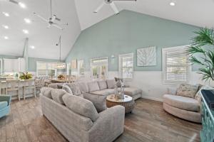 a living room with a couch and a table at Forever Coastal With Game Room And Private Beach in Destin