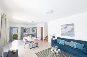 a living room with a blue couch and a table at Sea Satin Villas - Ayia Napa Center in Ayia Napa