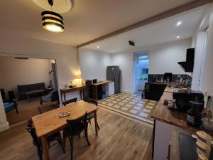 a large living room with a table and a kitchen at Maison Plestin proche plage et GR 34 avec Jardin in Plestin-les-Grèves +26 photos