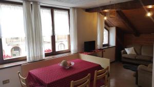 a room with a table with a red table cloth at Trentino, Grande Appartamento in Vermiglio +16 photos