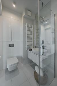 een witte badkamer met een toilet en een wastafel bij Wave Sea View Private Apartment - A864 in Międzyzdroje