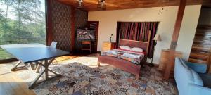 a bedroom with a bed and a table in a room at Corcovado Eco Lodge Villas-Houses-Tents-Mountain-Ocean Views in Puerto Jiménez