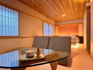 a living room with a glass table and a couch at HOTEL ZEN-Adult Only in Hirosaki